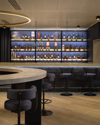 Corian bar counters and illuminated shelving displaying premium whisky brands