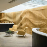 Feature wall constructed from individual timber shapes to form an organic backdrop to stylish office reception area