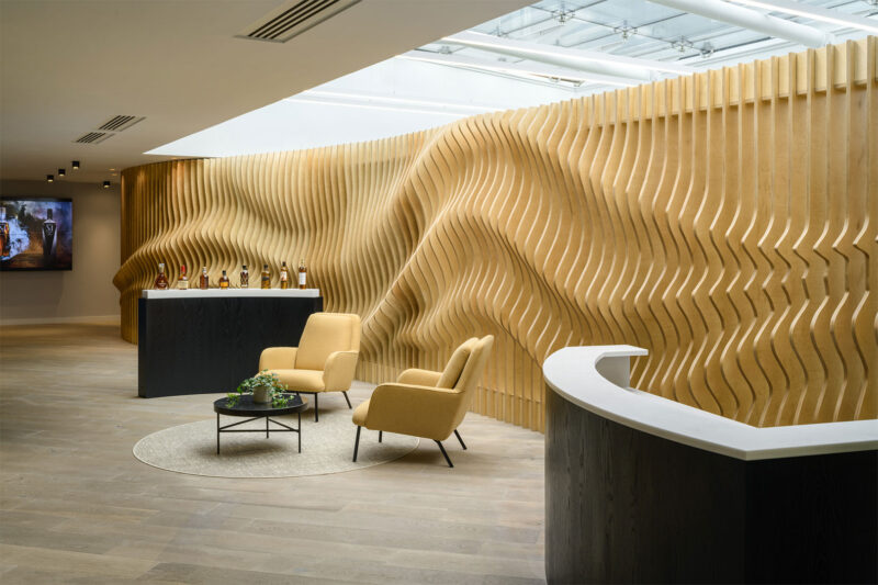 Feature wall constructed from individual timber shapes to form an organic backdrop to stylish office reception area